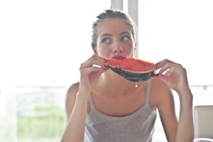 mulher comendo melancia, alimentação e saúde mental